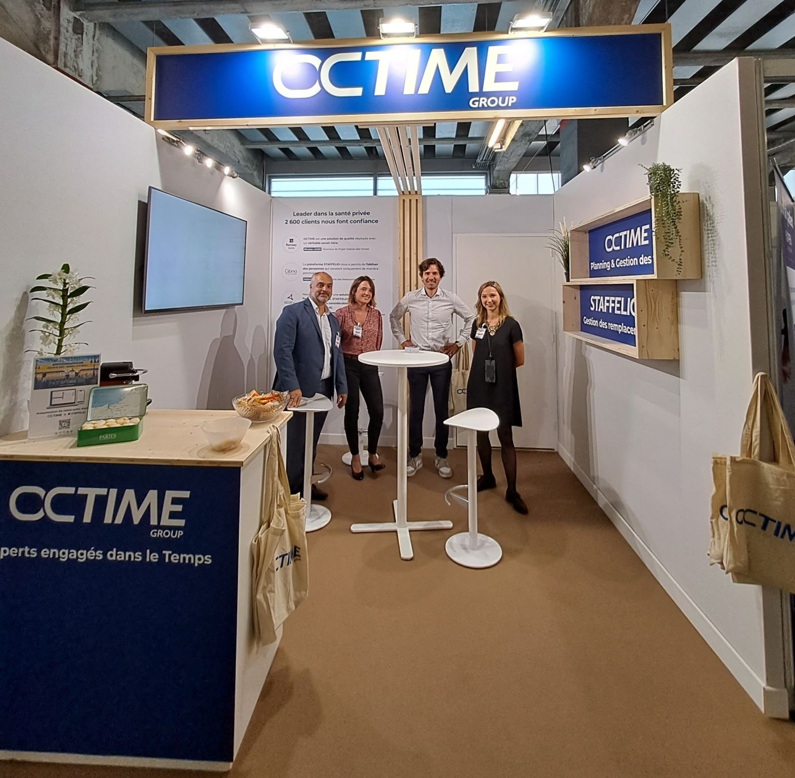 groupe-cctime-stand-exposition-equipe-accueillante-devant-presentoir