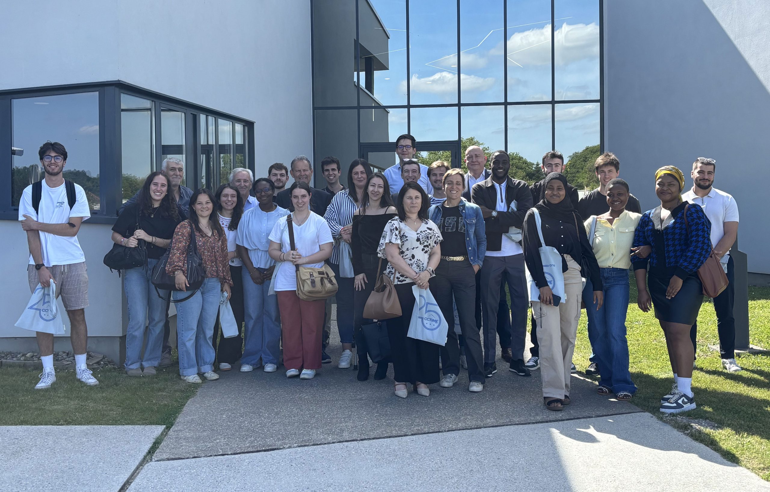 groupe-de-personnes-devant-un-batiment-moderne-sous-un-ciel-ensoleille