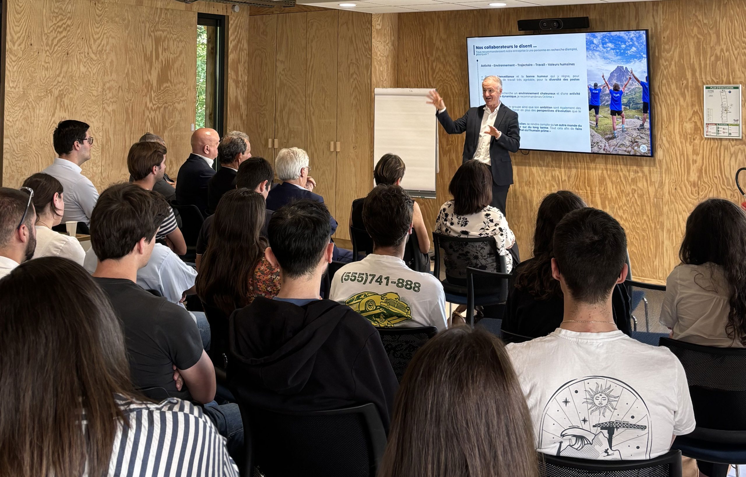 conference-presentateur-devant-participants-assis-dans-une-salle-polyvalente-en-bois